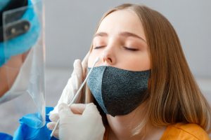 Doctor in blue gloves using a lateral flow covid-19 testing kit